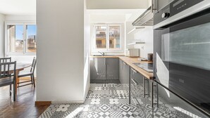 Eine moderne Küche mit einem großen Backofen, einer Holzarbeitsplatte und Fliesen mit Muster.