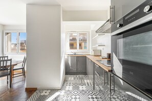 A modern kitchen with a large oven, a wooden countertop, and patterned floor tiles. - Large T4 refurbished - 3 bedrooms - Plein Centre (Marseille)