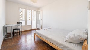Ein Schlafzimmer mit einem hölzernen Bett, einem Schreibtisch und einem Stuhl.