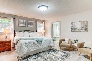 A bedroom with a bed, bedside tables, a chair, a rug, and artwork on the walls. - Large Home with Mountain View, Hot Tub and Sauna (McGaheysville)