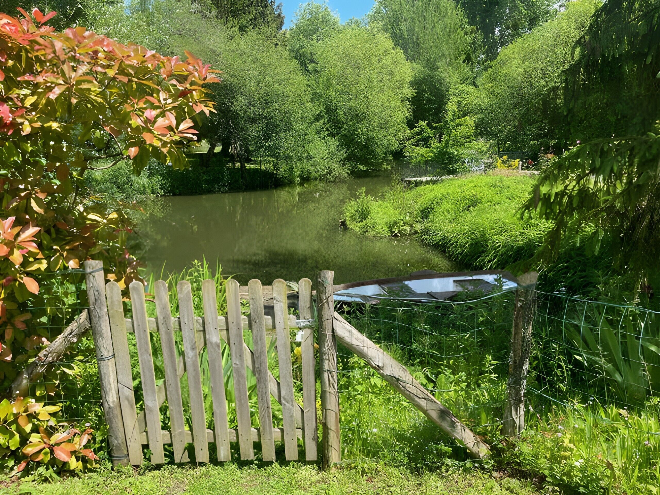 Une clôture en bois, une étendue d’eau et une végétation luxuriante.