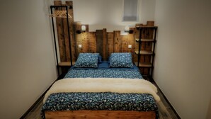 A bed with a floral-patterned bedspread, two matching pillows, and a fluffy white throw. - Bed and Breakfast 'La Suite Tilleul' with Shared Terrace, Shared Garden and Wi-Fi (Baugé-en-Anjou)