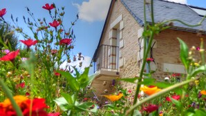 A building with a stone facade, a balcony with metal railings, and a clear sky. - Bed and Breakfast 'La Suite Tilleul' with Shared Terrace, Shared Garden and Wi-Fi (Baugé-en-Anjou)
