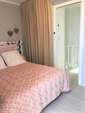 A bedroom with a bed, curtains, a headboard, and a wall-mounted light switch. - Campomoro - Beach apartment (Belvédère-Campomoro)