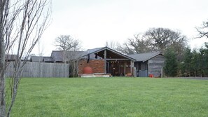 A house with a brick exterior, a wooden deck, and a fenced backyard.