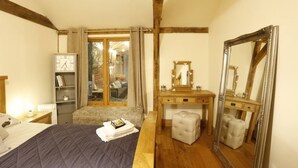 A bedroom with a bed, a dresser, a mirror, and a window with curtains.