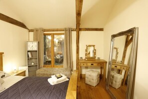 A bedroom with a bed, a dresser, a mirror, and a window with curtains. - Rushmoor Retreat, Cosy with Outdoor Pizza Oven (Bratton)