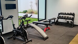 A gym with exercise equipment, a bench, and a dumbbell rack. - Stylish Studio in Bohemian Barranco · Work-Ready · Steps from Miraflores (Barranco)