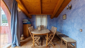 Une table de salle à manger en bois, avec des chaises, un banc et une fenêtre avec des rideaux.