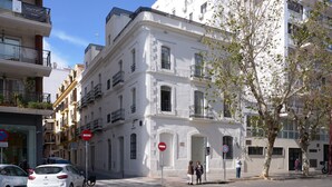A white building with balconies, a no entry sign, and a pedestrian crossing. - Luis de Vargas 1A by Home at Homes (Seville)