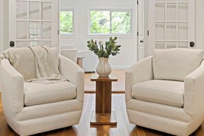 A room with two beige armchairs, a wooden coffee table, and a vase with greenery. - Holly House-1mi to UofA-0.5mi to RazorbackGreenway (Fayetteville)