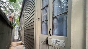 Eine schmale Holzdielenfläche führt zu einer Tür mit dem Schild 'Blues Room'.