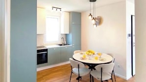 Eine moderne Küche mit Essbereich, Holzboden und einer hellblauen Wand.