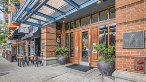 A brick building with a glass entrance, outdoor seating, and a sign for 'BELITOWN COURT.' - Elliott Bay View Condo Near Everything and Seattle Center with AC and More! (Seattle)