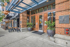 A brick building with a glass entrance, outdoor seating, and a sign for 'BELITOWN COURT.' - Elliott Bay View Condo Near Everything and Seattle Center with AC and More! (Seattle)