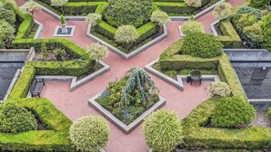 A landscaped courtyard with geometric garden beds, benches, and a central water feature. - Elliott Bay View Condo Near Everything and Seattle Center with AC and More! (Seattle)