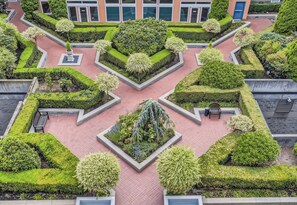 A landscaped courtyard with geometric garden beds, benches, and a central water feature. - Elliott Bay View Condo Near Everything and Seattle Center with AC and More! (Seattle)