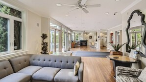 A spacious living area with a large gray sofa, a wooden coffee table, and a ceiling fan. - Elliott Bay View Condo Near Everything and Seattle Center with AC and More! (Seattle)