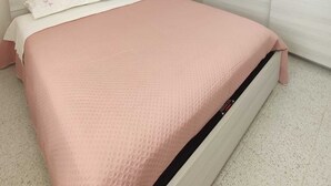 Un dormitorio con cama, armario y puerta que da a otra habitación.