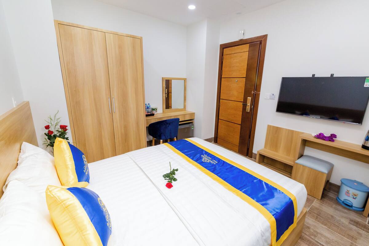 Ein Hotelzimmer mit Bett, Schreibtisch, Kleiderschrank und Fernseher.