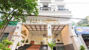 The entrance of Mai Hotel with a marble facade, a staircase leading to the entrance, and potted plants. - Mai Hotel Airport (Ho Chi Minh City)