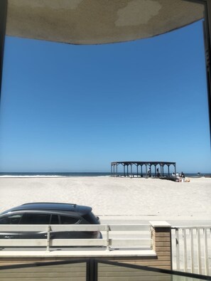 A beach view with a pavilion and a car in the foreground. - Apartment in Front of the Sea (Gafanha da Encarnação)