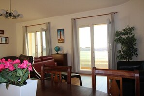 A dining area with a table, chairs, a globe, and a painting on the wall. - Apartment in Front of the Sea (Gafanha da Encarnação)
