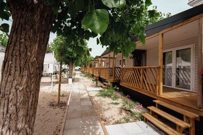 Eine Reihe von Holzhütten mit einer Holzterrasse und einem überdachten Außenbereich.