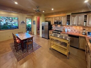 A kitchen with wooden cabinets, a stainless steel refrigerator, a microwave, and a gas stove. - Raven's Haven in the Heart of Santa Fe (Santa Fe)