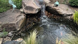 A small pond with a waterfall, surrounded by rocks and plants. - Raven's Haven in the Heart of Santa Fe (Santa Fe)