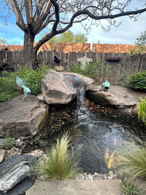 A small pond with a waterfall, surrounded by rocks and plants. - Raven's Haven in the Heart of Santa Fe (Santa Fe)