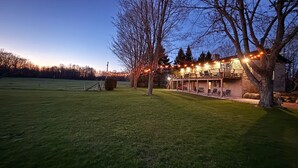 A house with a patio, a lawn, and a tree. - Ingrid’s Green Haven - 27 Acre Private Farm (Wiarton)