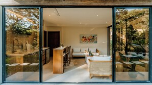 Een modern interieur met een keuken, een eethoek en een grote glazen deur naar een buitenruimte.