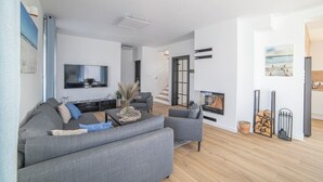 A modern living room with a grey sofa, a coffee table, and a flat-screen TV.