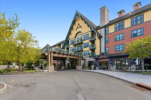 A multi-story hotel with a prominent A-shaped entrance, outdoor seating areas, and a landscaped courtyard. - Appalachian Hotel: LARGE 1 BEDROOM @ Mountain Creek, Pool, hot tub, ski, retreat (Vernon Township)