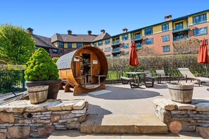 A rustic outdoor seating area with stone walls, a wooden barrel, and a patio table. - Appalachian Hotel: LARGE 1 BEDROOM @ Mountain Creek, Pool, hot tub, ski, retreat (Vernon Township)