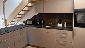 A modern kitchen with a built-in oven, a coffee maker, and a sink. - Delightful 3-bedroom apartment in charming Frutigen awaits you (Frutigen)