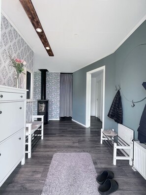 A narrow hallway with a wooden floor, a white bench, a radiator, and a coat rack. - Country House on a Horse Farm - Dogs welcome and you can rent horses. (Veddige)