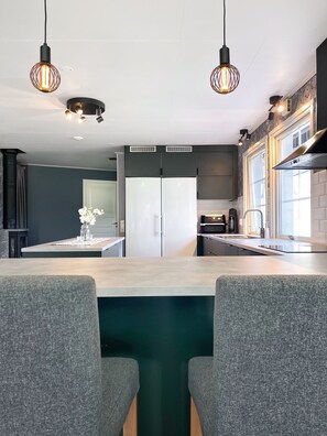 A modern kitchen with two pendant lights, a central island, and a built-in refrigerator. - Country House on a Horse Farm - Dogs welcome and you can rent horses. (Veddige)