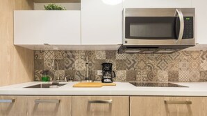 A kitchen with a microwave, a coffee maker, and a patterned backsplash. - 152 Sol by Stay with Bear (San Juan)