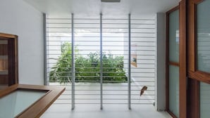 A room with a balcony, a wooden-framed window, and a metal rack. - 152 Sol by Stay with Bear (San Juan)