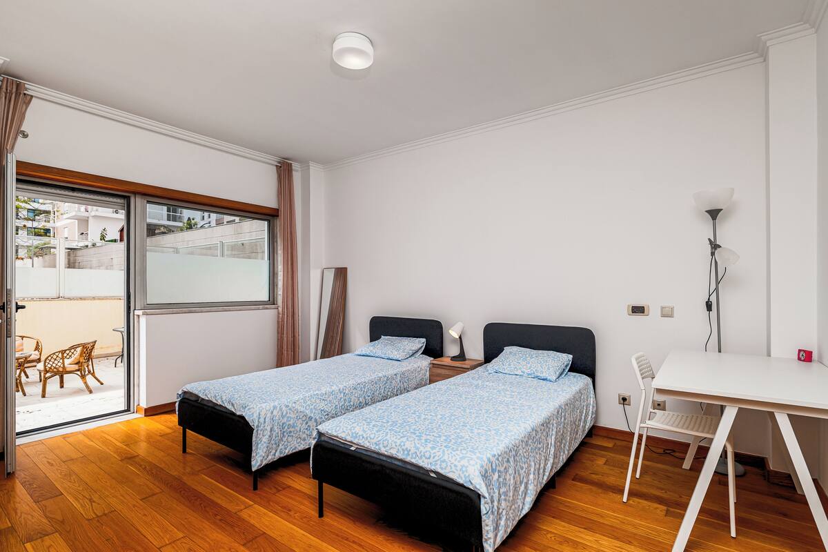 Une chambre avec deux lits, un bureau et une chaise.