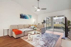 A modern living room with a sofa, coffee table, and a TV. - Coastal Vibes & Family Fun-Spacious 3BR, Kids Zone (Palm Coast)