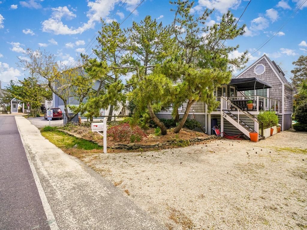 A residential property with a covered porch, a staircase, and a small garden area.