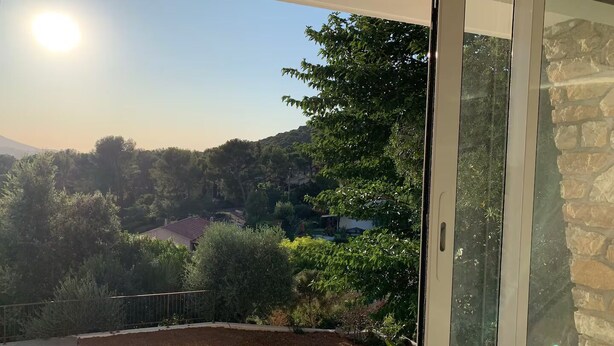 A balcony with a clear view of a mountainous landscape, a swimming pool, and a stone wall. - Apartment ❤️ quiet and air-conditioned, sea on foot in 7 min! (carqueiranne)