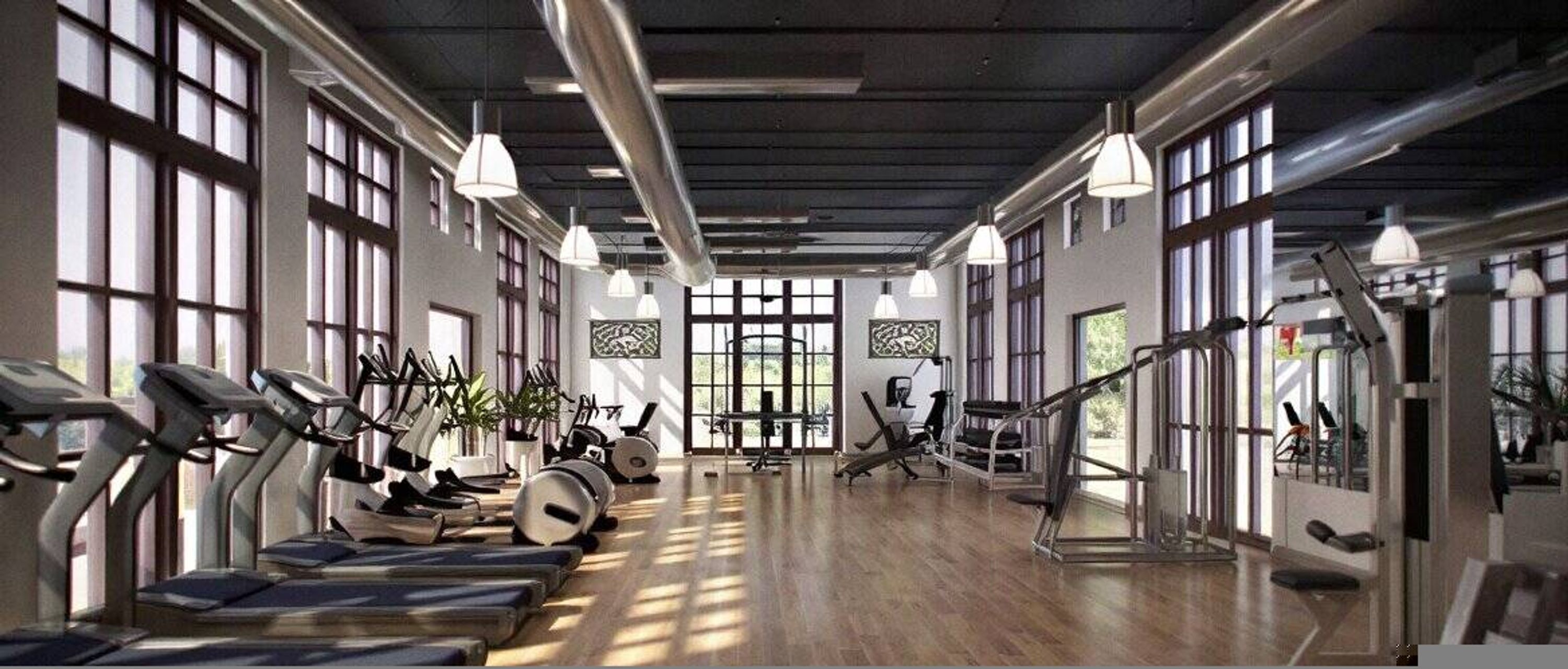 A gym with treadmills, elliptical machines, and weight equipment.