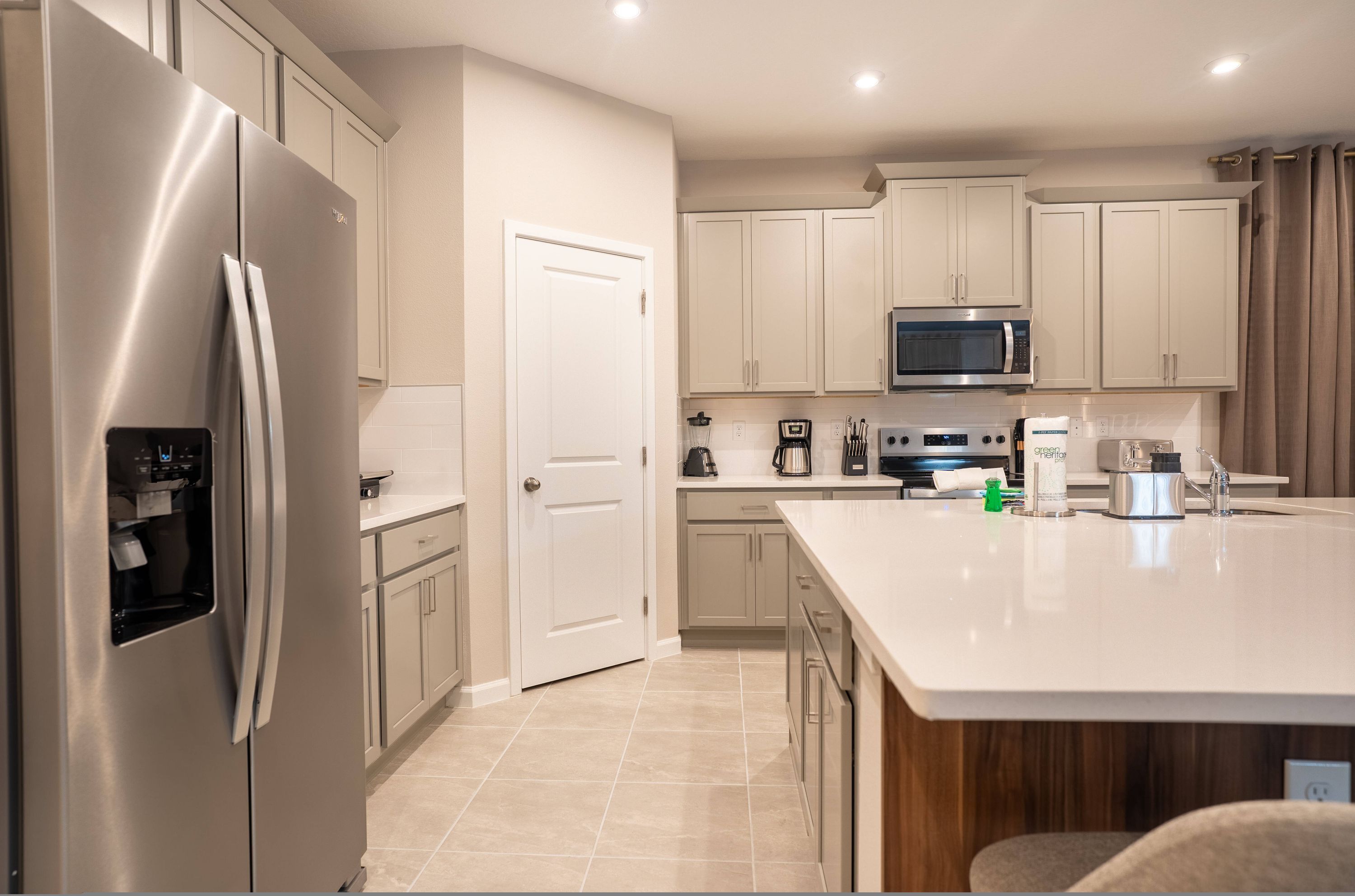Una cocina moderna con electrodomésticos de acero inoxidable, armarios blancos y una isla grande.