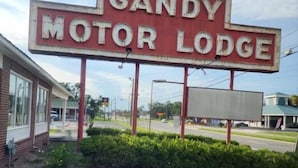 A Gandy Motor Lodge sign with a parking lot in front.