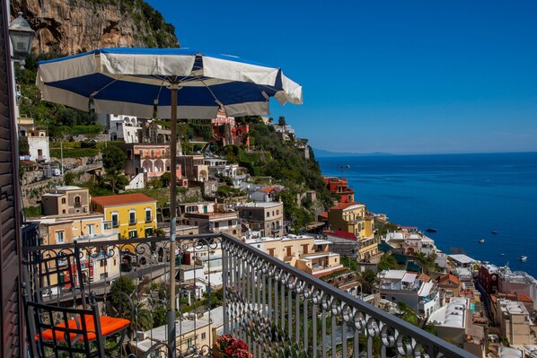 A coastal town with colorful buildings, a balcony with a railing, and a clear blue sky. - M'incanto Holiday home (Campania)