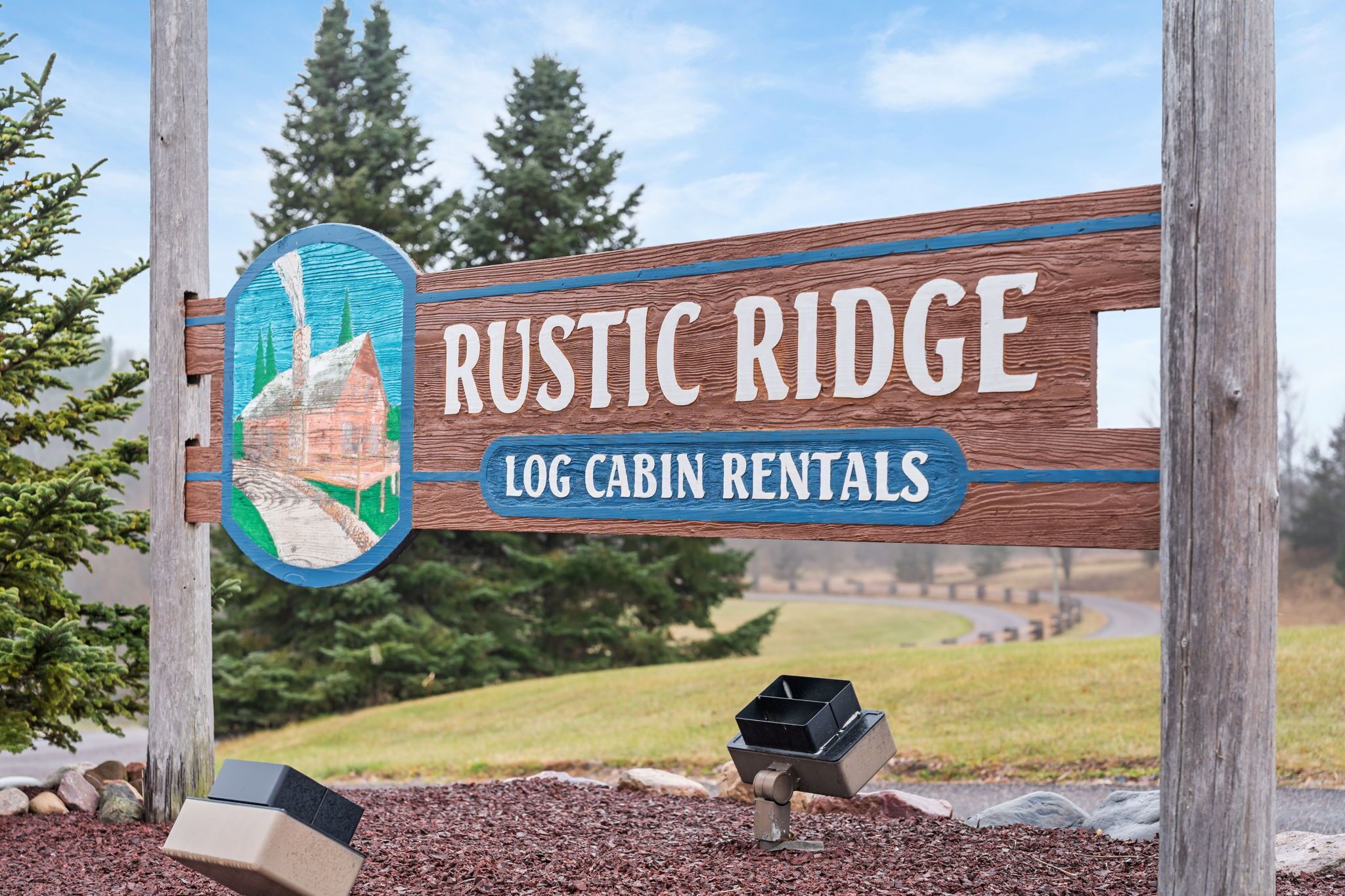 A wooden sign with 'Rustic Ridge Log Cabin Rentals' written on it.
